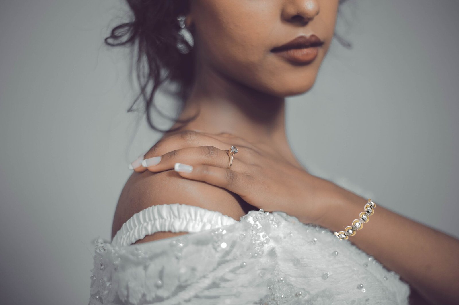 Un bracelet aux détails dorés et argentés porté avec une robe blanche
